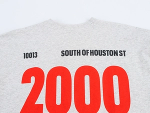 Detail shot of the letter print and number 2000 on this grey loose round neck T-shirt