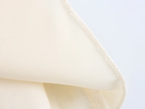 Detailed view of cream woven fabric showing high-quality stitching and seaming finish