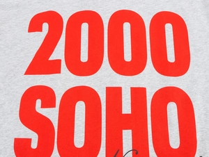 Close-up of red 2000 SOHO lettering printed on grey knit fabric of a summer t-shirt