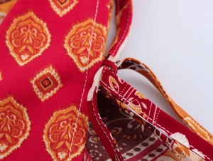 Detailed macro view of ethnic red fabric with mandala print and stitching on straps