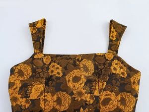 Detail view of the brown and gold jacquard fabric featuring floral patterns and square neck