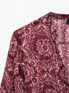 Détail du col en V et de l'imprimé mandala sur la robe bordeaux à manches longues