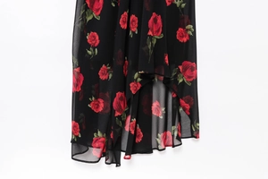 Detail of red rose floral print on asymmetrical black chiffon hemline of a dress