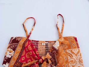 Close-up of paisley floral print on boho camisole with adjustable straps and bow