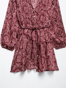 Détail d'une robe bohème à col en V avec motif paisley et détails à volants