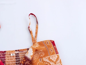Detail of bohemian printed top featuring smocking texture and adjustable straps