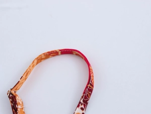 Close-up of ethnic print shoulder strap with white stitching and metal adjustment ring