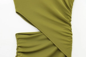 Detail of olive green sleeveless dress featuring asymmetric cutout and side ruched fabric
