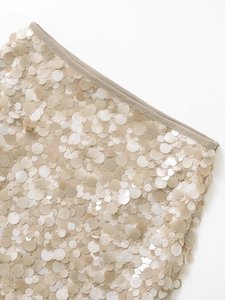 Detailed view of beige sequins on a mini skirt with high-quality edge stitching