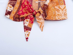 Macro detail of bohemian floral print fabric with front tie knot and pleated texture