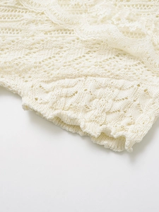 Close-up of cream white lace knit fabric with intricate floral crochet patterns