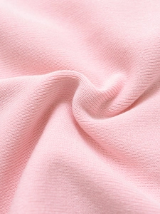 Detail of pink knitted ribbed fabric texture showing soft pleats and fine workmanship
