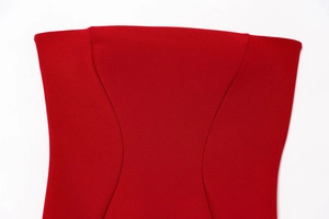 Dettaglio ravvicinato delle cuciture curve su un abito estivo rosso aderente