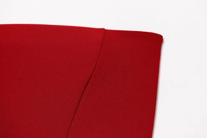 Dettaglio macro della trama del tessuto rosso scuro e cuciture fini del vestito