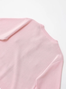 Detail view of pink knit dress showing ribbed crew neck and fine fabric texture