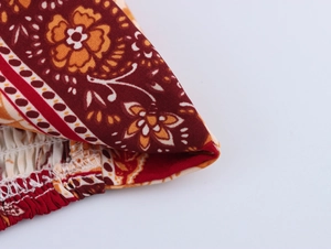 Detailed macro view of bohemian floral print and smocked waistband elastic fabric texture