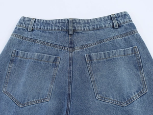 Vue détaillée des poches arrière d'un jean bleu foncé avec surpiqûres orange