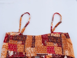 Detail of bohemian paisley print top with elastic smocking and delicate straps