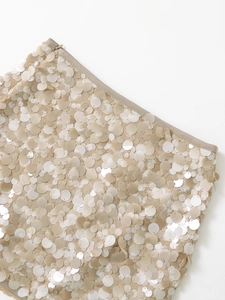 Close-up of champagne sequins and fine stitching with invisible zipper detail