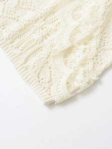 Close-up of white lace crochet fabric with intricate hollow pattern and scalloped edges