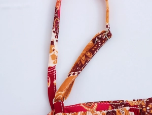 Detailed macro view of adjustable shoulder strap and bohemian print on a summer top