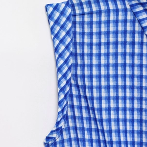 Detailed view of blue and white gingham woven fabric with clean shoulder stitching