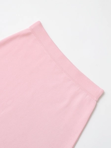 Close-up of light pink knit dress showing fine texture and ribbed waistband details