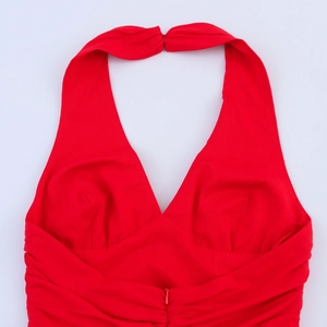 Détail d'une robe licou rouge avec décolleté en V profond, fronces et fermeture éclair