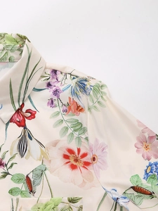 Detailed close-up of a satin floral shirt showing the lapel collar and breast pocket