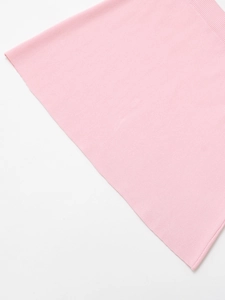 Detail of pink knit dress showing fine ribbing texture and high-quality craftsmanship