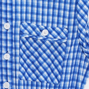 Detail of blue and white gingham romper featuring chest pocket and white buttons