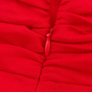 Vue macro d'une robe rouge montrant le tissu texturé avec des fronces et une fermeture éclair