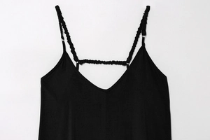 Dettaglio di abito nero con scollo a V e spalline elastiche con design arricciato