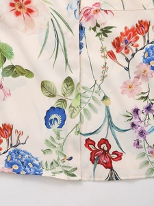 Macro shot of satin shirt fabric with vibrant floral lilies and detailed stitching