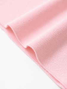 Close-up of pink knit fabric showing detailed fine stitch texture and soft elasticity