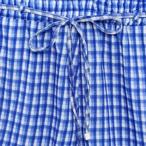 Detail of blue gingham fabric featuring elastic waist with drawstring and bow knot