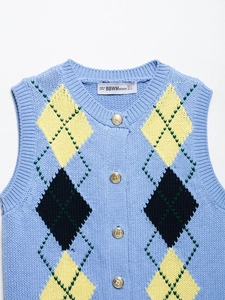 Detailed close-up of light blue knit vest with yellow argyle pattern and gold buttons