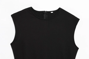 Detail of a black sleeveless dress showing the round neck and discreet back zipper closure
