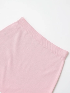 Detailed close-up of pink knit fabric with ribbed hem and high-quality textured finish