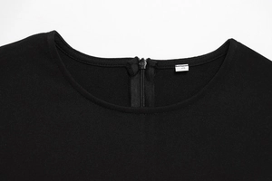Macro detail of the neckline and back zipper closure on this black sleeveless dress