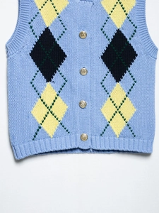 Close-up of argyle knit pattern and vintage gold crest buttons on the blue vest