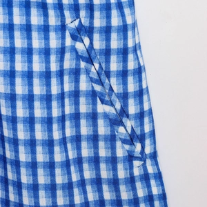 Detail of side pocket and blue checkered cotton fabric texture on summer jumpsuit