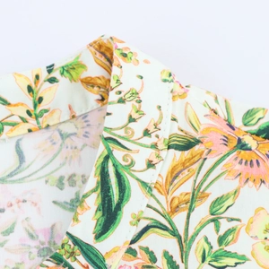 Detailed close-up of standard collar and floral tropical print on woven summer dress fabric