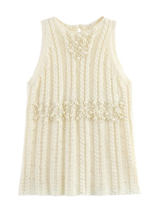 Detail of cream cable knit vest with elegant pearl embellishments on the neckline