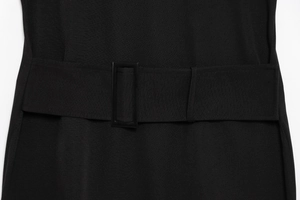 Close-up of the black dress waist featuring a wide belt and rectangular matte buckle