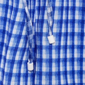 Detail of blue and white gingham fabric featuring an adjustable drawstring waist cord