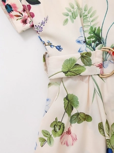Detailed macro view of silk-texture floral fabric and belt with golden metal buckle