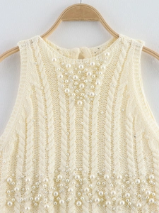 Detailed cable knit pattern on sleeveless vest featuring hand-applied pearls and round neck