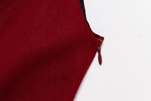 Detail of burgundy sleeveless dress featuring a seamless matching hidden zipper and woven texture