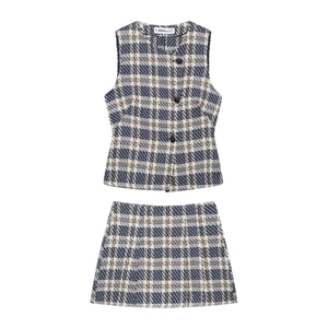 Détail de l'ensemble gilet et minijupe en tweed bleu à carreaux avec boutons noirs